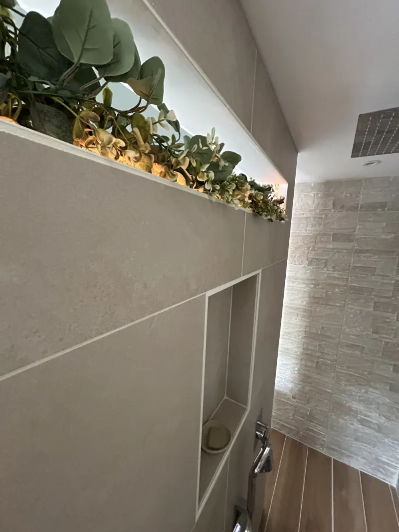 Jardinière éclairée posée sur une cloison de douche carrelée