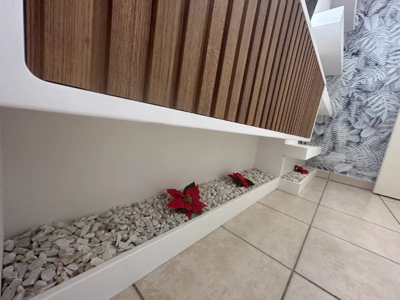 Lames de bois au mur et bac de galets blancs le long de la plinthe